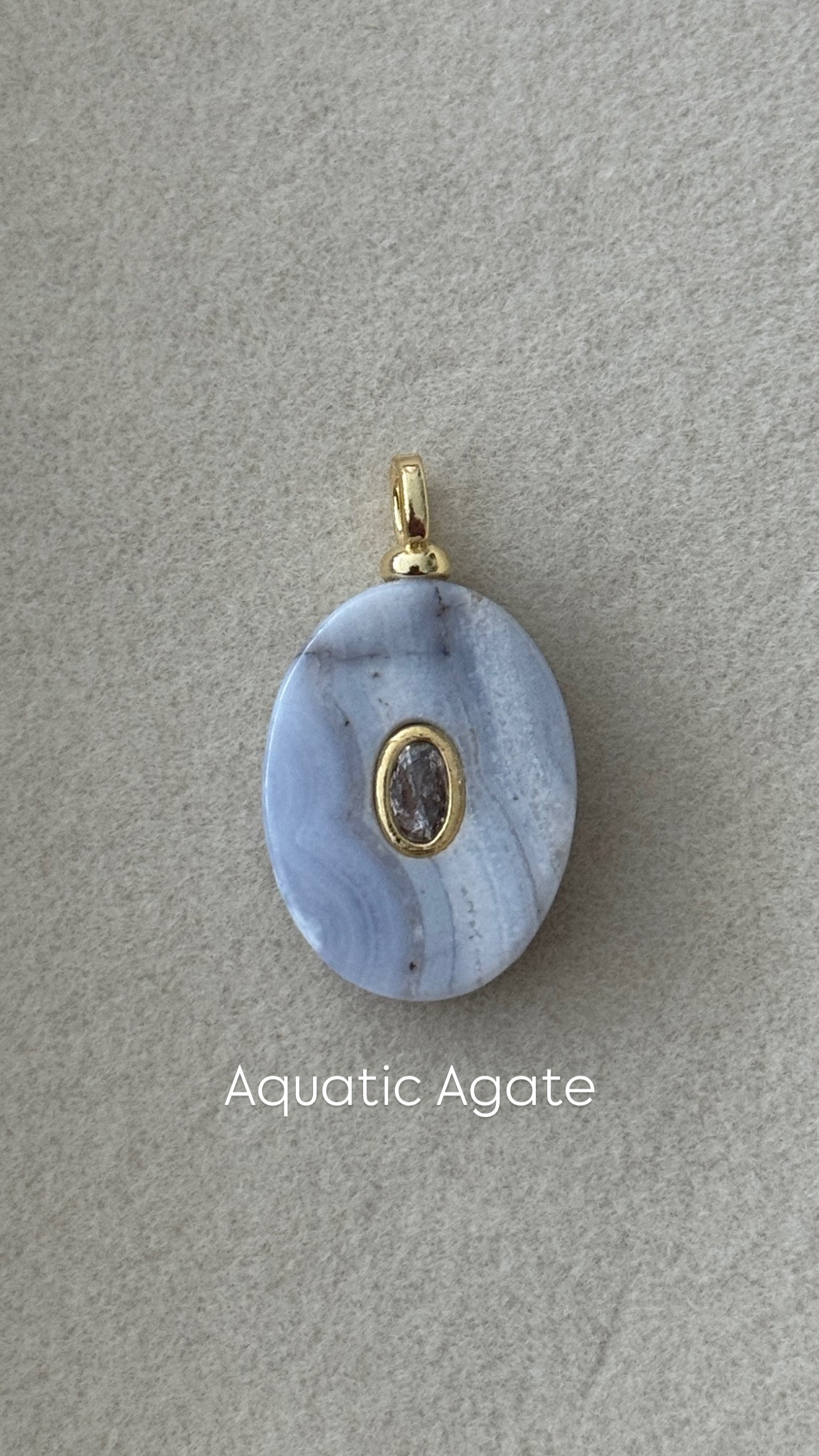 Blue agate pendant with gold accent on a gray background