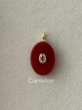 Carnelian pendant with gold and silver accents on a gray background